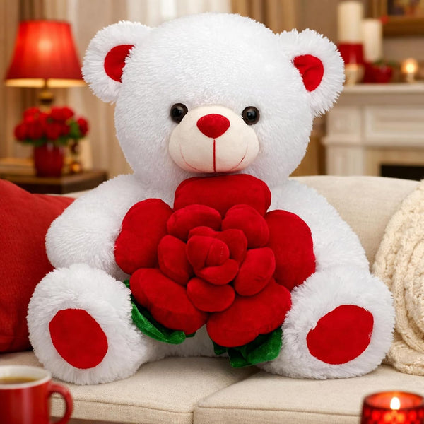 White teddy bear holding red roses on a couch with a cozy background